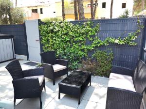 patio z krzesłami, stołem i ogrodzeniem w obiekcie 5005 Mas de la Pinède 141 w Cap d'Agde