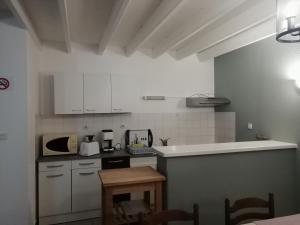 a small kitchen with white cabinets and a table at Villa Jozefina résidence les Oyats in Jullouville-les-Pins