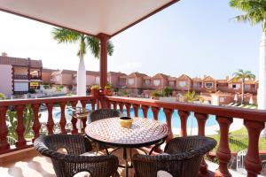a table and chairs on a balcony with a view at Two modern and bright apartments near el Duque beach in Adeje