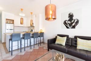 a living room with a couch and a kitchen at Two modern and bright apartments near el Duque beach in Adeje