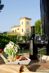 einen Tisch mit zwei Gläsern Wein und einem Teller Essen in der Unterkunft B&B Live09 Design in Pisa