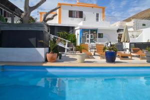 a swimming pool with potted plants and a house at CASA RURAL GA7COLORES only adult in Montaña Blanca