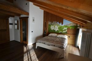 a bedroom with a bed in a room with wooden ceilings at Rifugio Lo Scoiattolo in Peio