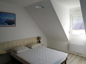 a bedroom with a bed and a window at Villa Jozefina résidence les Oyats in Jullouville-les-Pins