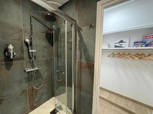 eine Dusche mit Glastür im Badezimmer in der Unterkunft Appart Standing - La Coque d'Or - Mont-St-Michel in Le Mont Saint Michel + 11 Fotos