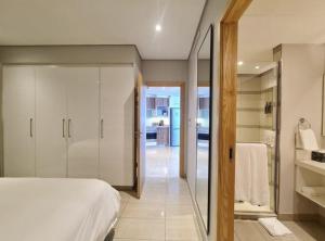 ein Schlafzimmer mit einem Bett und einer ebenerdigen Dusche in der Unterkunft The Pearls Umhlanga in Durban