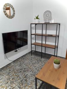 Una sala de estar con una mesa y un televisor. en Casa Fayacanes, en La Ampuyenta