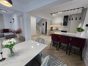 a kitchen and living room with a white table and chairs at Elira Lake in Buhalniţa