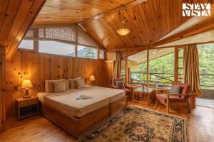 une chambre avec un lit dans une pièce aux murs en bois dans l'établissement StayVista at Himalayan Retreat Luxury 9BR, 6BR 5BR, 3BR 1BR Villa in Manali, à Manali