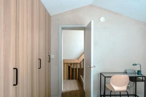 Cette chambre dispose d'une porte, d'une chaise et d'un escalier. dans l'établissement Modern Chatham home with garden retreat, à Chatham 23 autres photos