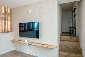 a living room with a flat screen tv on a wall at Modern Chatham home with garden retreat in Chatham