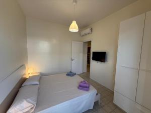 a small bedroom with a bed and a tv at La casa di Lilly in Villaggio Azzurro