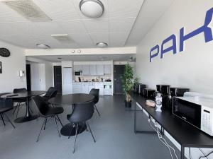 an office with tables and chairs and a wall with a pharmacy sign at Kotimaailma - Vihtyisä Hostelli in Kokkola
