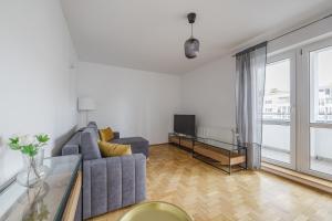 a living room with a couch and a tv at Katowicka Comfort Apartment by BookingHost in Poznań