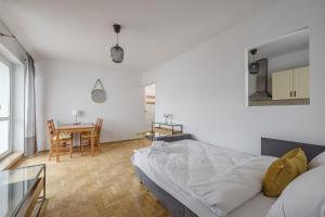 a white bedroom with a bed and a table at Katowicka Comfort Apartment by BookingHost in Poznań +54 photos