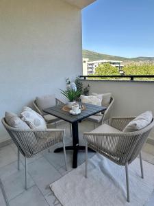 a patio with a table and chairs on a balcony at Apartment Cashmere in Trebinje