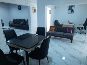 a living room with a black table and chairs at Olu-Mayowa Apartments in Ibadan