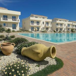a large yellow vase sitting next to a swimming pool at Marzamemi Holidaydream Sea View in Marzamemi