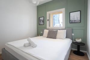 Un dormitorio con una gran cama blanca con ventana. en 175 Design Residence - With mamad, en Tel Aviv