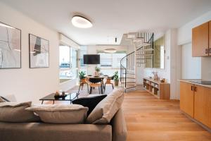 a living room with a couch and a table at 175 Design Residence - With mamad in Tel Aviv