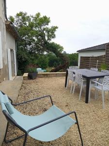 a blue chair and a table and chairs on a patio at L'ORME DE PEYNON Nature - repos - méditation 