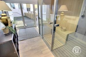 a room with a glass hallway with a table and a lamp at Le semaphore in Saint-Cast-le-Guildo