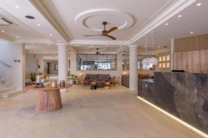 a living room with a ceiling fan and a couch at Zeus Hotels Neptuno Beach in Amoudara Herakliou