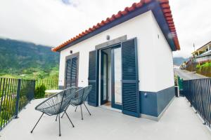 a house with two chairs and a table on a balcony at A Casa da Graça Reis by Horizon View Madeira in São Vicente