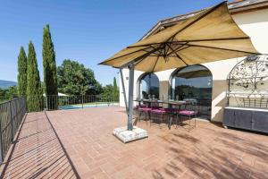 a patio with a table and a large umbrella at Casina al Vento by Mmega in Levane