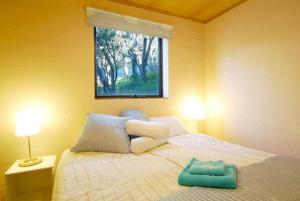 a bedroom with a bed with a green towel on it at KILIMANJARO ALPINE APARTMENTS 3 BEDROOM Apartment in Falls Creek