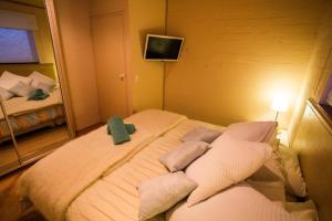 a bedroom with a bed with pillows and a mirror at KILIMANJARO ALPINE APARTMENTS 3 BEDROOM Apartment in Falls Creek