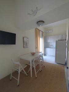 a kitchen with a table and chairs and a refrigerator at Sunshine Apartment in Kamena Vourla +3 photos