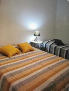 a bedroom with two beds and a table with a lamp at Appartement confort in Île de Diane