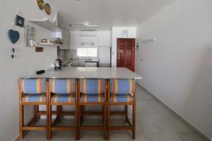 a kitchen with a counter and some chairs in it at 24 Isikhulu Umdloti Beachfront in Umdloti