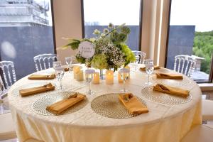 a round table with a white tablecloth and gold napkins at Whistler Garden Hotel in Sungaitahang