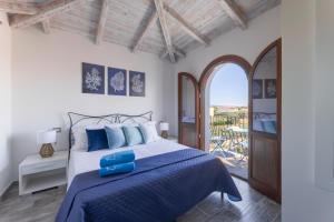 a bedroom with a large bed with blue pillows at Riva rooms - by Obiettivo vacanza Budoni in Budoni