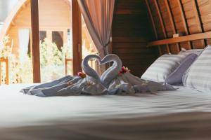 two swans making a heart on a bed at Loka Sea View Glamping in Pengastulan