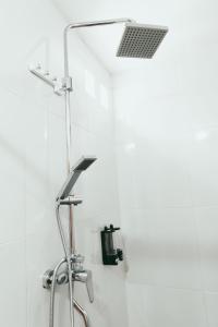 a shower in a white bathroom with a sink at Loka Sea View Glamping in Pengastulan