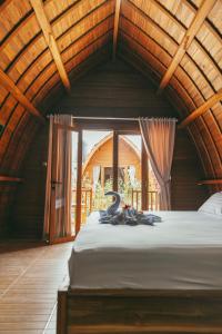 a bedroom with a large bed with a large window at Loka Sea View Glamping in Pengastulan +27 photos