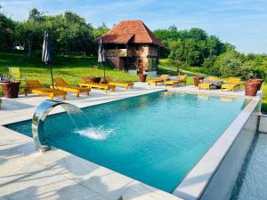 a swimming pool with benches and a gazebo at Vikend na Ozrenu in Bosansko Petrovo Selo