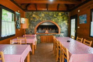 a restaurant with two tables and a fire place at House Pavlic in Grabovac
