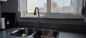 a kitchen sink with a faucet next to a window at Big,Smart & Comfort ! in Kalamata +24 photos