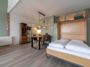 Un dormitorio con una cama y un comedor. en Apartment by Dutch Coast with Dune Views, en Julianadorp