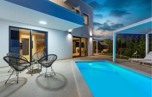 a house with a swimming pool and two chairs at Cozy Home In Linardici in Linardići