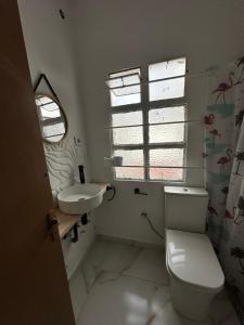 Un baño con inodoro, lavabo y ventana. en Habitación individual con baño compartido, en Algeciras