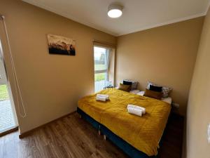 a bedroom with a bed with yellow sheets and a window at Apartamenty pod Szczęśliwym Koniem 
