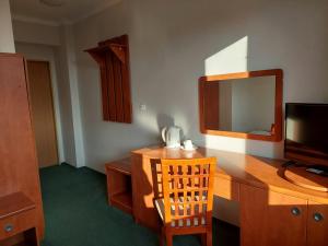 a room with a desk with a television and a mirror at Dom Studencki Rubin in Kalisz