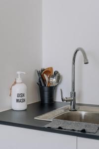 a kitchen counter with a sink and a dish wash container at SUMMER SUITES APARTMENT CASETTA HOMESTAY 3A at Kota Samarahan Kuching in Kuching