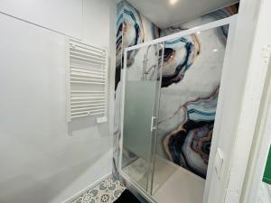 een glazen kast met schilderijen erop in een badkamer bij Appartement Nid Douillet Plus in Tourcoing