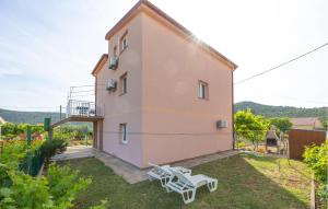 un edificio con dos bancos blancos en un patio en 2 Bedroom Amazing Apartment In Poljica, en Poljica